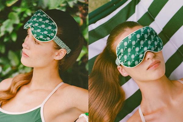 Woman wearing a green silk sleep mask with a pattern, outdoors.